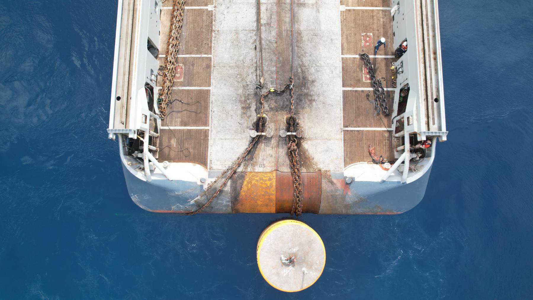 Aerial view of mooring chains running from a work deck to a buoy