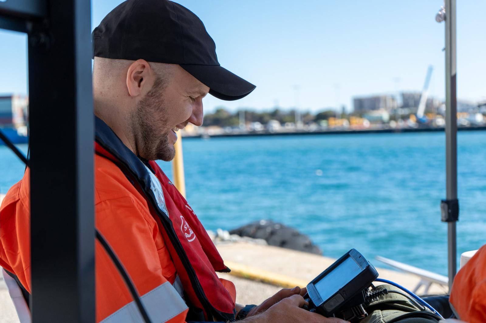 Operator using a handheld control unit dockside