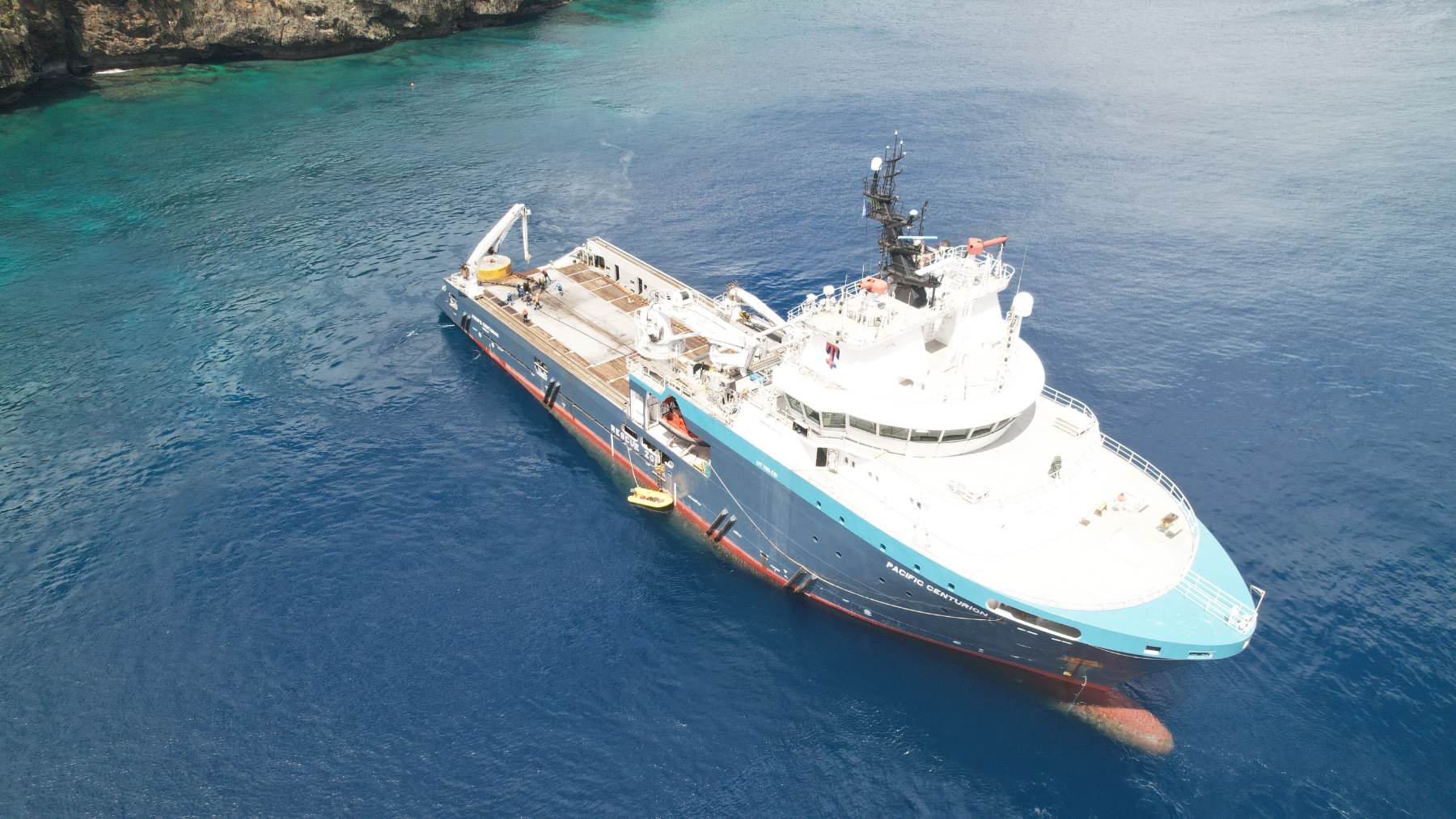 Offshore support vessel at anchor beside a reef edge